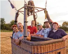  ??  ?? Ballonführ­er Andreas Kindler (Dritter von links) hat seine Passagiere gegen 21.30 Uhr sicher zurück auf den Boden gebracht.