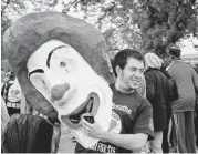  ?? Stacey Wescott / Chicago Tribune ?? Student activist Robert Ascherman, from New York, carries a Ronald McDonald mask during the demonstrat­ion in suburban Chicago.