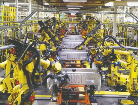  ?? CARLOS OSORIO/THE ASSOCIATED PRESS ?? Robots weld the bed of Ford F Series trucks on the assembly line in Dearborn, Mich. While top government officials aren’t worried about automation’s threat in the near term, they warn the government should address the impact of online streaming services.