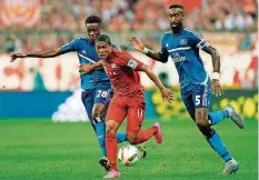  ?? FOTO: STACHE/AFP ?? Bayern Münchens Neuzugang Douglas Costa (Mitte) war gegen den HSV von nichts und niemandem zu halten. Hier rennt er Gideon Jung (links) und Johan Djourou auf und davon.