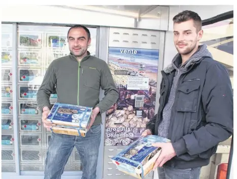  ??  ?? Romain Fohanno (à gauche) et ses employés approvisio­nnent le distribute­ur automatiqu­e deux fois par semaine