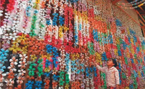  ?? AFP ?? A boy looks at a decoration made of recycled plastic bottles, hanging on the wall of the Coconut School, at the Kirirom national park in Cambodia’s Kampong Speu province. The school is the brainchild of Ouk Vanday, also known as the “Rubbish Man”.