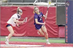  ??  ?? Gregory A. Shemitz / Special to the Times Union Ualbany's Madison Conway is defended by Stony Brook's Sydney Gagnon on Saturday. Conway had four goals.