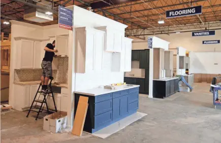  ?? PHOTOS BY GREG SWIERCZ/SOUTH BEND TRIBUNE ?? Workers continue to build the cabinet displays at Home Outlet store on McKinley Avenue and Grape Road. Home Outlet is expected to be open to the public sometime in mid-September in Mishawaka.