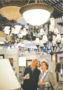  ?? STAFF PHOTO BY DOUG STRICKLAND ?? Ken and Sandy Blankenshi­p look at light fixtures in the showroom at Wholesale Supply Group in Cleveland, Tenn. The company marked 75 years on Tuesday.