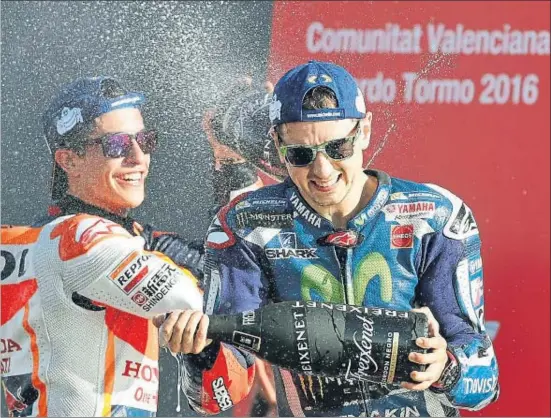  ?? MANUEL BRUQUE / EFE ?? El campeón Marc Márquez sonríe en el podio al lado del triunfador de la jornada, Jorge Lorenzo