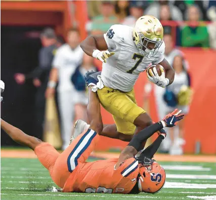  ?? ADRIAN KRAUS/AP ?? Notre Dame’s Audric Estime runs over Syracuse linebacker Alijah Clark during the first half Saturday in Syracuse, N.Y. Estime ran for 123 yards and two touchdowns on 20 carries in the Irish’s 41-24 win.