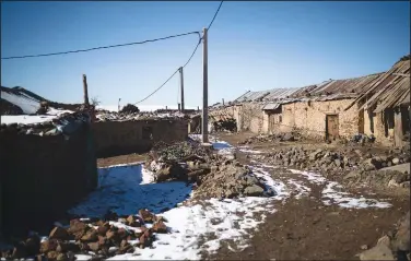  ?? ?? Sheep that nomadic Amazigh tribes rely on for living huddle inside a barn amidst snowfall in the village.
Snow is seen on the ground in the village.