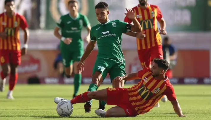  ?? Photo © Domenic Aquilina ?? Birkirkara's Claudio Bonanni (R) goes in hard with his challenge to foil the onrushing Nicolas Garcia (L) of Floriana.