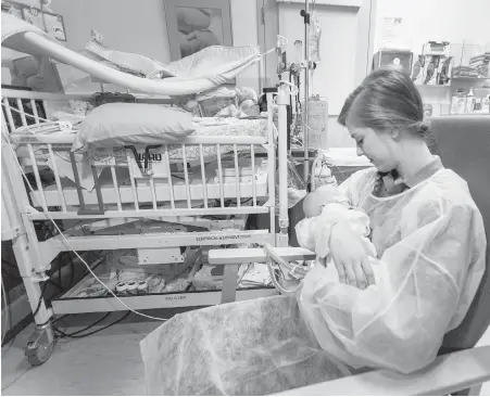  ??  ?? Sarah Byam holds baby Lady in the neonatal intensive care unit at the introducti­on of a baby-hugging program at Victoria General Hospital.