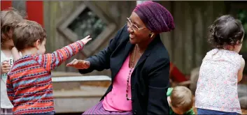  ??  ?? In this photo taken Aug. 27, teacher Fatuma Yusuf interacts playground at the Wallingfor­d Child Care Center in Seattle. AP Photo/ElAInE thomPSon