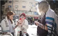  ?? (Noam Revkin Fenton/Flash90) ?? WOMEN OF the Wall lay tefillin in downtown Jerusalem yesterday.