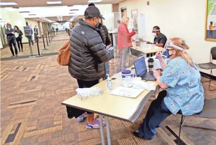  ?? MIKE DE SISTI/USA TODAY NETWORK ?? People register for rapid-result coronaviru­s testing at UW-Milwaukee on Nov. 16, 2020. Some public health experts fear the spring semester’s timing could exacerbate the state of the pandemic.