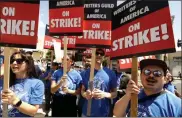  ?? ?? Writers Guild of America members walk the picket line on the first day of the WGA’s strike in front of Paramount Studios in Hollywood, California, on May 2.