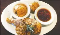  ?? PHOTO BY GILBERT STRODE ?? Southern Twice Fried Chicken is served with, from left, cheese grits, a cheddar biscuit and tomato bacon jam at Carabelle’s Casual Cafe in Dayton, Tenn.