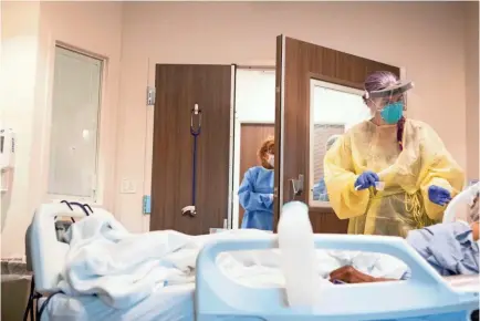  ?? JPHOTOS BY OE RONDONE/THE COMMERCIAL APPEAL ?? Registered Nurse Sheila Purcell works with a patient inside Methodist University Hospital's COVID unit on Friday, Aug. 21, 2020.