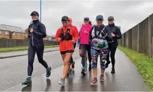  ??  ?? Andrea Bradley (second right) completing the 2020 virtual London Marathon in Neath.