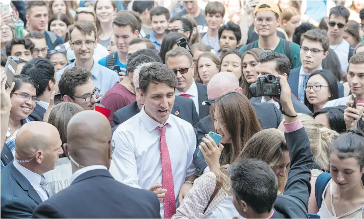  ?? PAUL CHIASSON / THE CANADIAN PRESS ?? Prime Minister Justin Trudeau makes his way through a crowd of students from McGill University on Friday in Montreal.