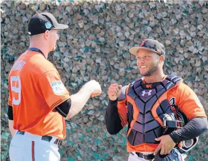  ?? EDUARDO A. ENCINA/BALTIMORE SUN ?? New Orioles catcher Welington Castillo gives young pitcher Mike Wright a fist bump during spring training exercises. Castillo will be with the Orioles in Sarasota, Fla., for two weeks before he joins the Dominican Republic team for next month’s World...