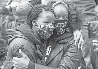  ?? TREVOR HUGHES/USA TODAY ?? Selena McKnight, 46, hugs her daughter, Jalyn Hall, 18, on Tuesday outside the Hennepin County Government Center in Minneapoli­s following the conviction of former police officer Derek Chauvin.