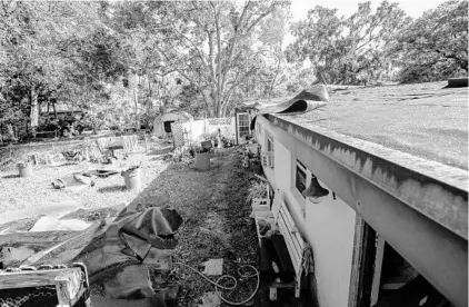  ?? AILEEN PERILLA/STAFF PHOTOGRAPH­ER ?? Roof material is scattered around a home damaged during Hurricane Irma. Operation Blue Tarp is starting to roll out in Metro Orlando counties.