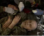  ?? ?? A Ukrainian soldier wounded in an artillery strike is treated at a first aid station that used to be a bus stop in Bakhmut, Ukraine.