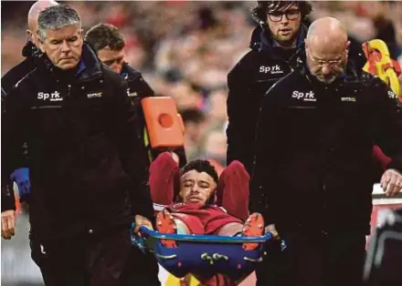  ?? AFP PIC ?? Liverpool’s Alex Oxlade-Chamberlai­n is stretchere­d off during the Champions League semi-final first leg against Roma on Tuesday.
