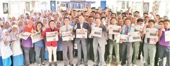  ??  ?? From fifth left: Herman, Roslan, Lau and Wong distributi­ng The Borneo Post and Utusan Borneo to the students.