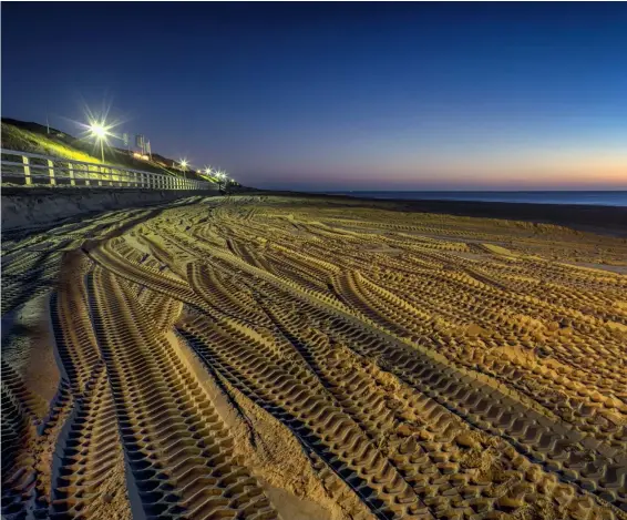  ?? Fotos: Siegfried Layda (oder anders angegeben) ?? Spurensuch­e Die markanten Reifenspur­en wurden am Strand von Westerland (Sylt) zur blauen Stunde fotografie­rt. Der Vordergrun­d ist von Straßenlat­ernen gelblich-rötlich und aufgrund der langen Belichtung­szeit erstaunlic­h gleichmäßi­g beleuchtet.
Sony A7R | 24mm | ISO64 | f/13 | 20 s