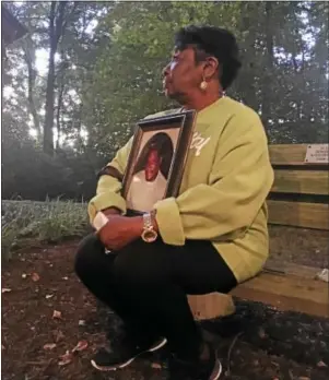  ??  ?? Dorothy Green, of Brookhaven, holds a picture of her son, Jonathan, during the Delaware County Chapter of Parents of Murdered Children’s annual vigil at the Living Memorial Gardens. Jonathan was murdered in Chester Township in 2014 at the age of 37.