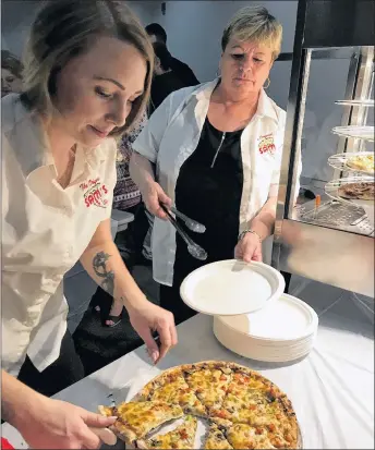  ??  ?? Waitresses Ashley Gerrior (left) and Dawn Hayman prepare pizza for customers at the Rotary Pizza Fest at the Pictou County Wellness Centre on Saturday.