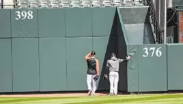  ?? BALTIMORE SUN FILE,LEFT; KEVIN RICHARDSON/BALTIMORE SUN ?? The late Elrod Hendricks, left, enjoys a laugh on the May 2005 day he returned to Camden Yards after a stroke. Right, Orioles players check the cushion on the new left field wall on Opening Day at Camden Yards.