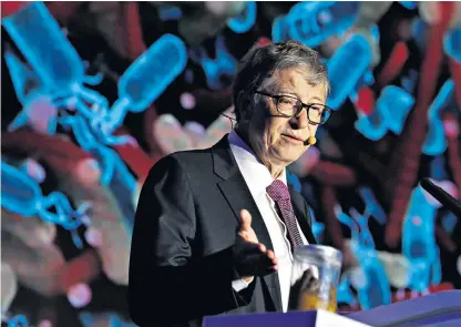  ??  ?? Microsoft founder Bill Gates points at the jar of human faeces during his speech at the Reinvented Toilet Expo showcasing sanitation technology