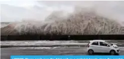  ?? —AFP ?? LONDON: Waves crash over the tidal wall as a motorist travels along the coastal road in New Brighton, north west England yesterday as Storm Eleanor swept over the country.