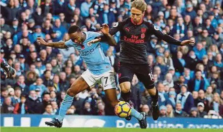  ?? REUTERS PIC ?? Manchester City’s Raheem Sterling (left) is brought down in the area by Arsenal’s Nacho Monreal resulting in a penalty during their match at the Etihad Stadium on Sunday.