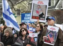  ?? CHRIS CHRISTO — BOSTON HERALD ?? Residents listen to a speaker during the gathering to rebuild the vandalized hostage memorial wall in front of a home on Homer Street in Newton, Sunday.