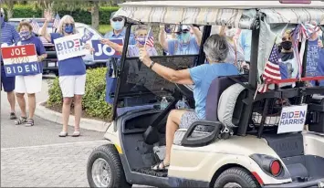  ?? John Raoux / Associated Press ?? Supporters cheer and wave signs as voters arrive at the Sumter County Elections office to drop off their ballots after taking part in a parade of golf carts supporting Democratic presidenti­al candidate Joe Biden Wednesday in The Villages, Fla.