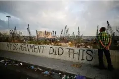  ??  ?? A man stands next to graffiti at the damaged port area in the aftermath of the massive explosion (Reuters)