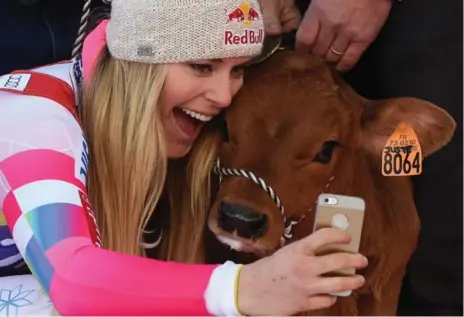  ?? PHILIPPE DESMAZES/AFP/GETTY IMAGES ?? Lindsey Vonn takes a selfie with a calf on the podium after winning the FIS Alpine World Cup Women’s Downhill in France on Saturday.