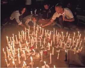  ??  ?? Indonesian residents light candles during a vigil for the victims of the church attacks in Surabaya. FULLY HANDOKO/EPA-EFE