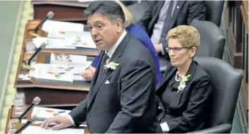  ?? NATHAN DENETTE/THE CANADIAN PRESS ?? Ontario Finance Minister Charles Sousa, left, delivers the Ontario 2016 budget next to Premier Kathleen Wynne, right, at Queen’s Park in Toronto on Feb. 25, 2016. Ontario’s Liberal government will release its first balanced budget in a decade on...