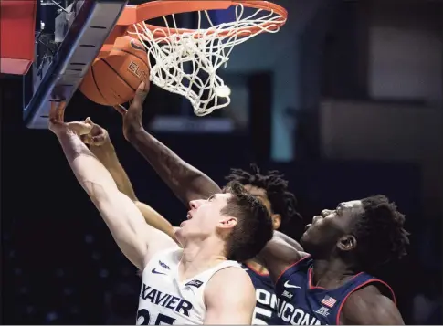  ?? Albert Cesare / Associated Press ?? UConn’s Adama Sanogo, right, blocks Xavier’s Jason Carter in the second half on Saturday.