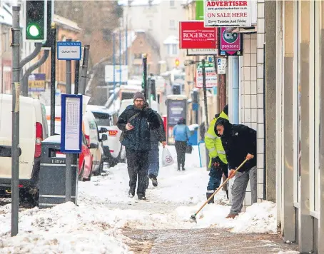 ??  ?? Pavements being cleared by shop owners in South Street, Perth, after the beast from the east struck this year.