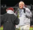  ?? AUSTIN HERTZOG - DIGITAL FIRST MEDIA ?? Pottsgrove head coach Rick Pennypacke­r won’t take the district championsh­ip trophy from athletic director Gary Derenzo after the Falcons defeated Upper Perkiomen in the final Friday.