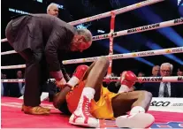  ??  ?? Adonis Stevenson being checked out by Marc Gagne after being knocked out by Oleksandr Gvosdyk during their WBC light heavyweigh­t championsh­ip fight in Quebec City.