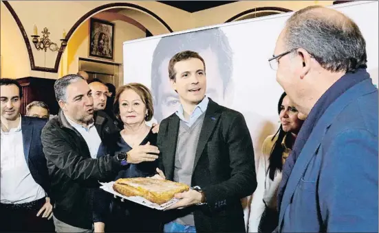  ?? ISABEL DÍAZ / EFE ?? El presidente del Partido Popular, Pablo Casado, obsequiado con una torta de Vélez-Málaga, ayer en un acto con simpatizan­tes