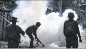  ?? BRIAN INGANGA / ASSOCIATED PRESS ?? A gas canister releases smoke in front of a riot policeman Monday in the Mathare slum neighborho­od of Nairobi, Kenya, as opposition supporters clash with government forces in election unrest.