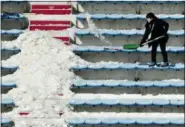  ?? CHARLIE RIEDEL — THE ASSOCIATED PRESS ?? A workers shovels snow and ice from the seating area at the Alpensia Ski Jumping Center ahead of the 2018 Winter Olympics in Pyeongchan­g, South Korea, Wednesday.