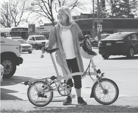  ?? DAN JANISSE ?? Lori Newton, executive director of Bike Windsor Essex, holds her ride at the corner of Lauzon Parkway and Tecumseh Road East — identified as the most dangerous cycling intersecti­on in Windsor. The group wants designated bike lanes for safety reasons.