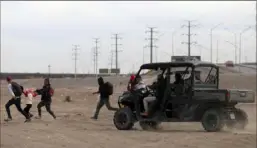  ?? Herika Martinez/AFP via Getty Images ?? Agents of the National Migration Institute chase a group of migrants seeking asylum in the U.S. on Tuesday as they attempt to cross the Rio Grande River by Ciudad Juarez, Mexico.